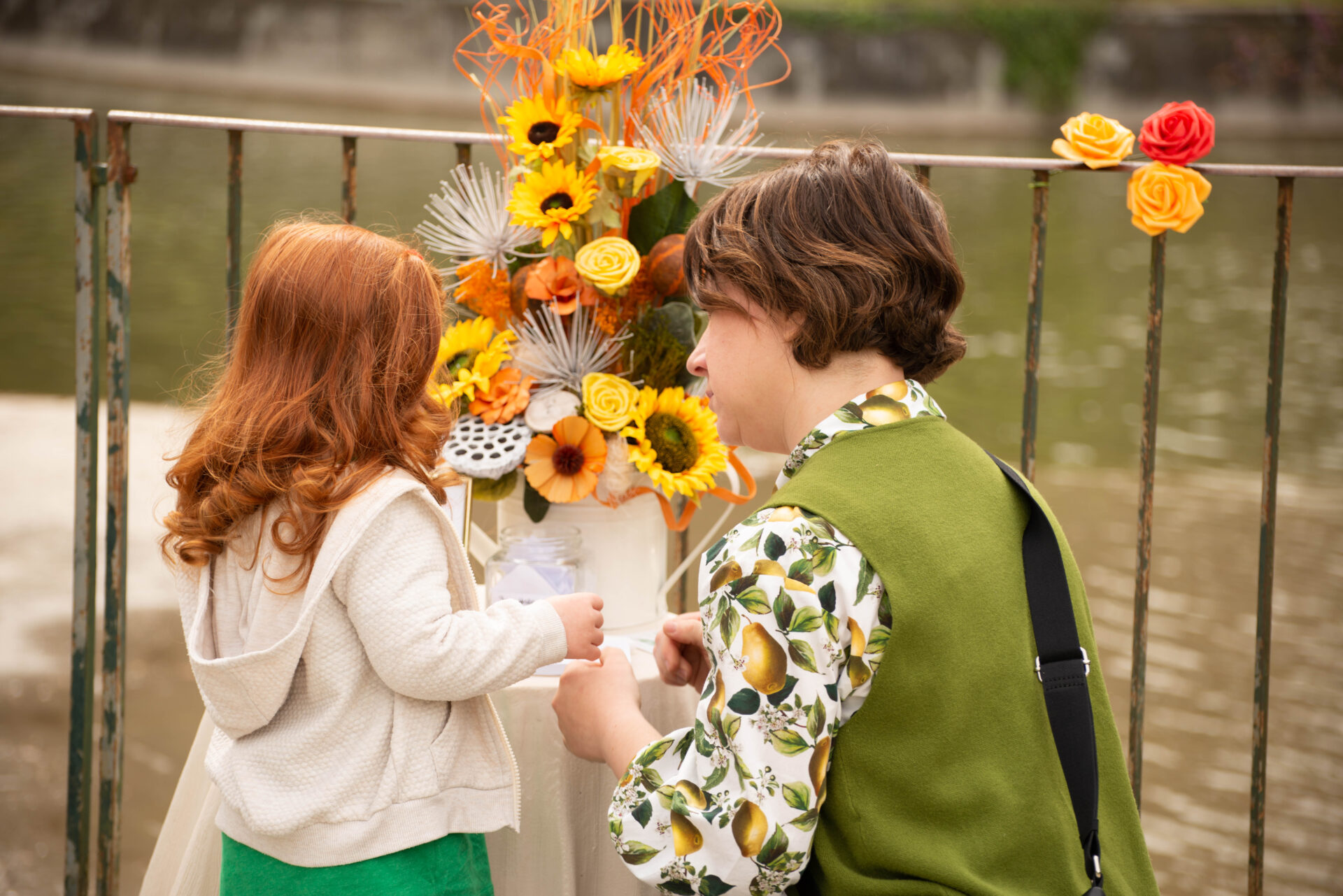 Una bimba dai capelli rossi intenta a scrivere il suo desiderio sotto la guida di sua mamma